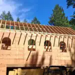 Large arched window openings and roof framing taking shape on a Washington State custom home.