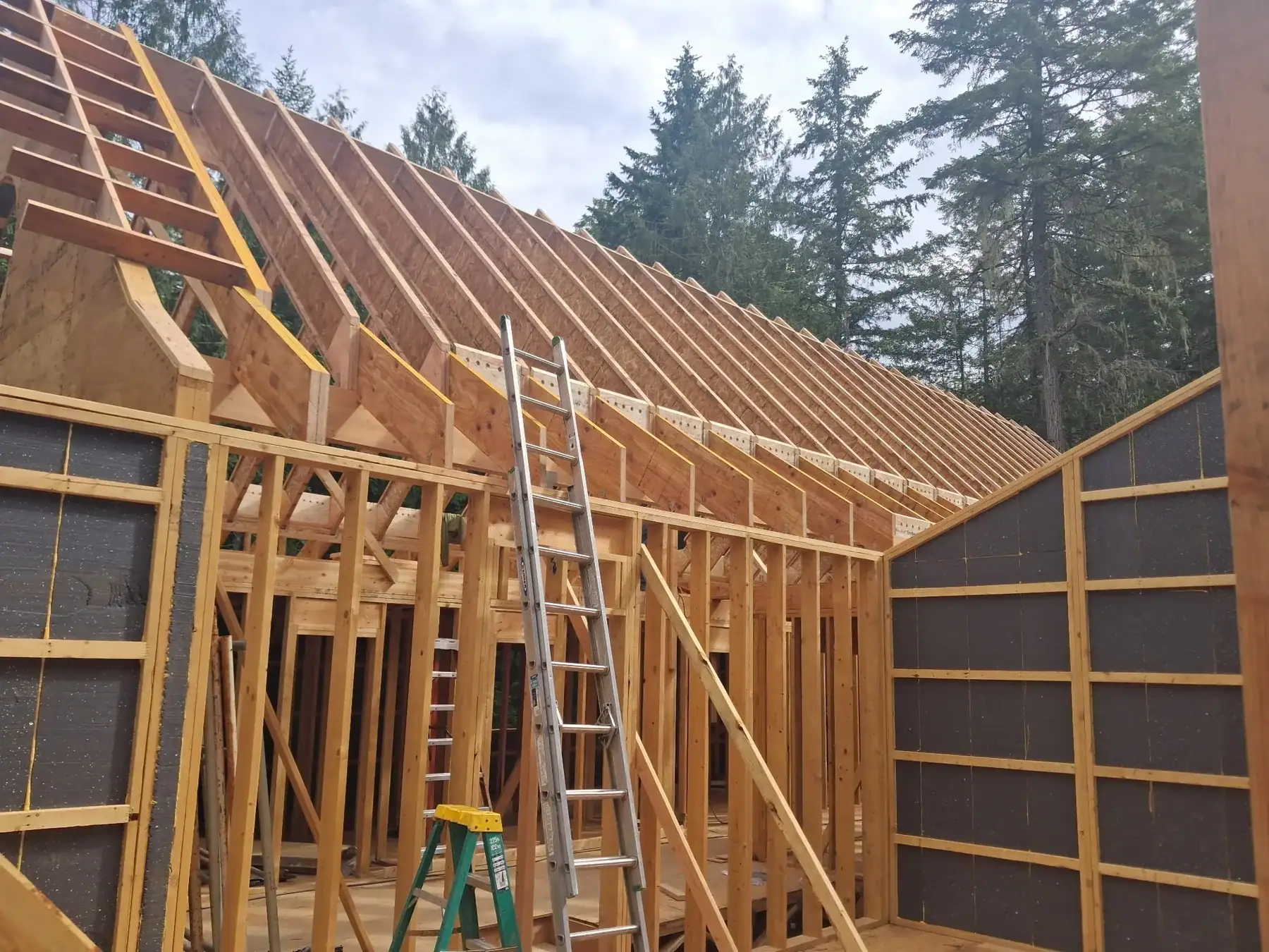 Interior timber roof framing under construction on a custom Tamlin home package.